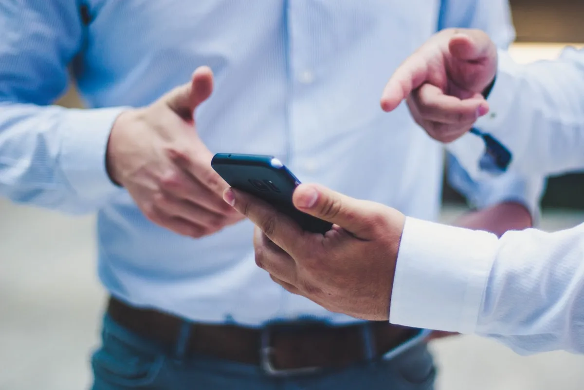 Duas pessoas comparando informações no celular