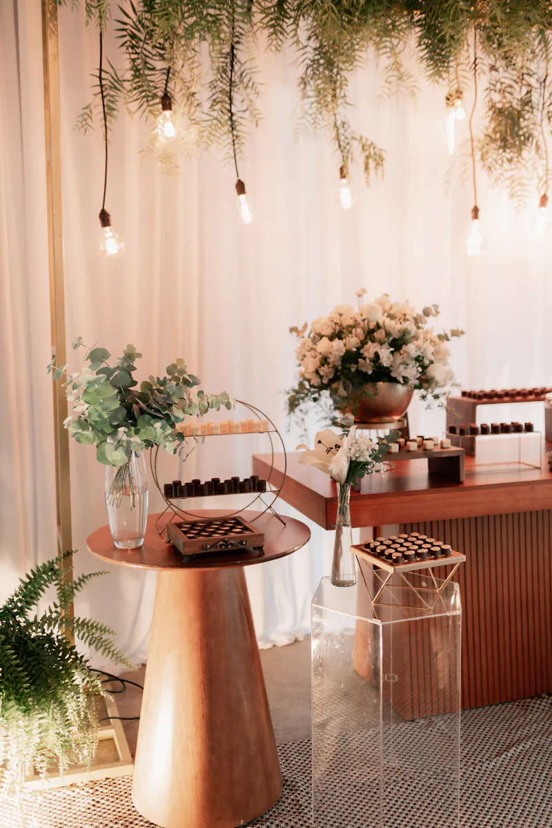 Mesa de doces decorada com flores e luzes